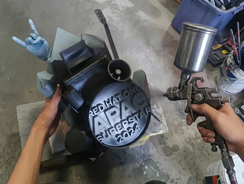 redhat 3d print giant trophy. this photo show the spray painting in progress. We have skill craftsman to do the job.