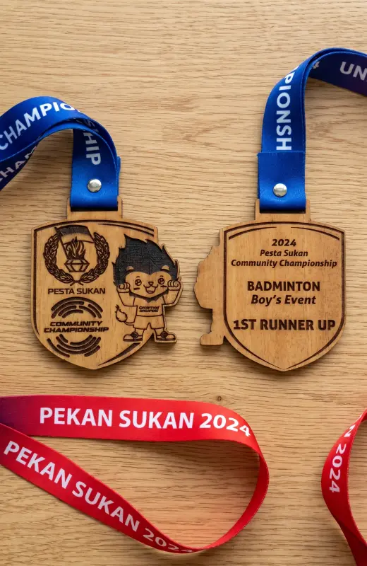 pekan sukan 2024 medal for badminton event. The size is 10x7cm and thickness is 5mm. We are using laser engraving but we do not charred the wood medal, giving the clean look